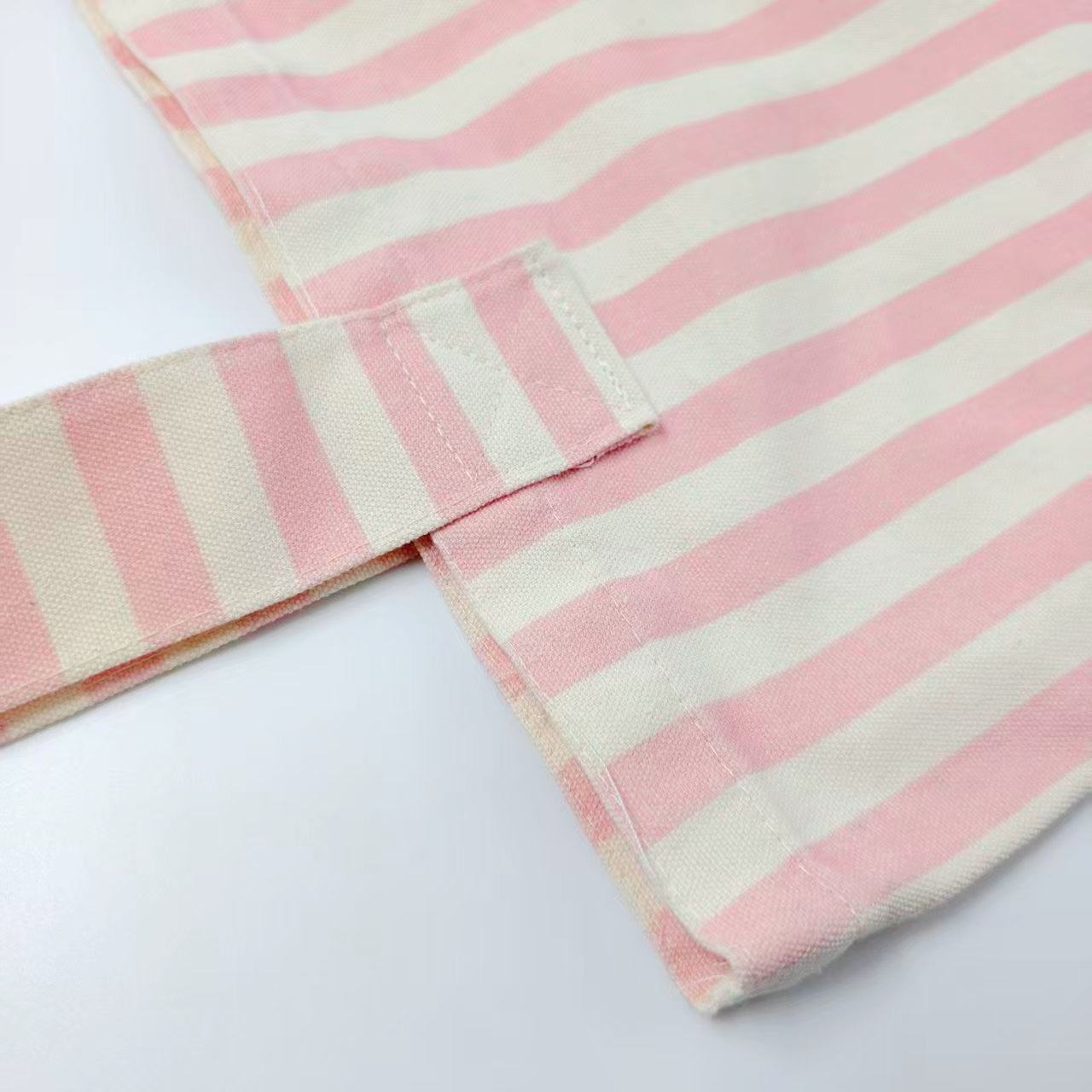 Pink and white striped fabric shopping bag close-up showing surface weave and seams