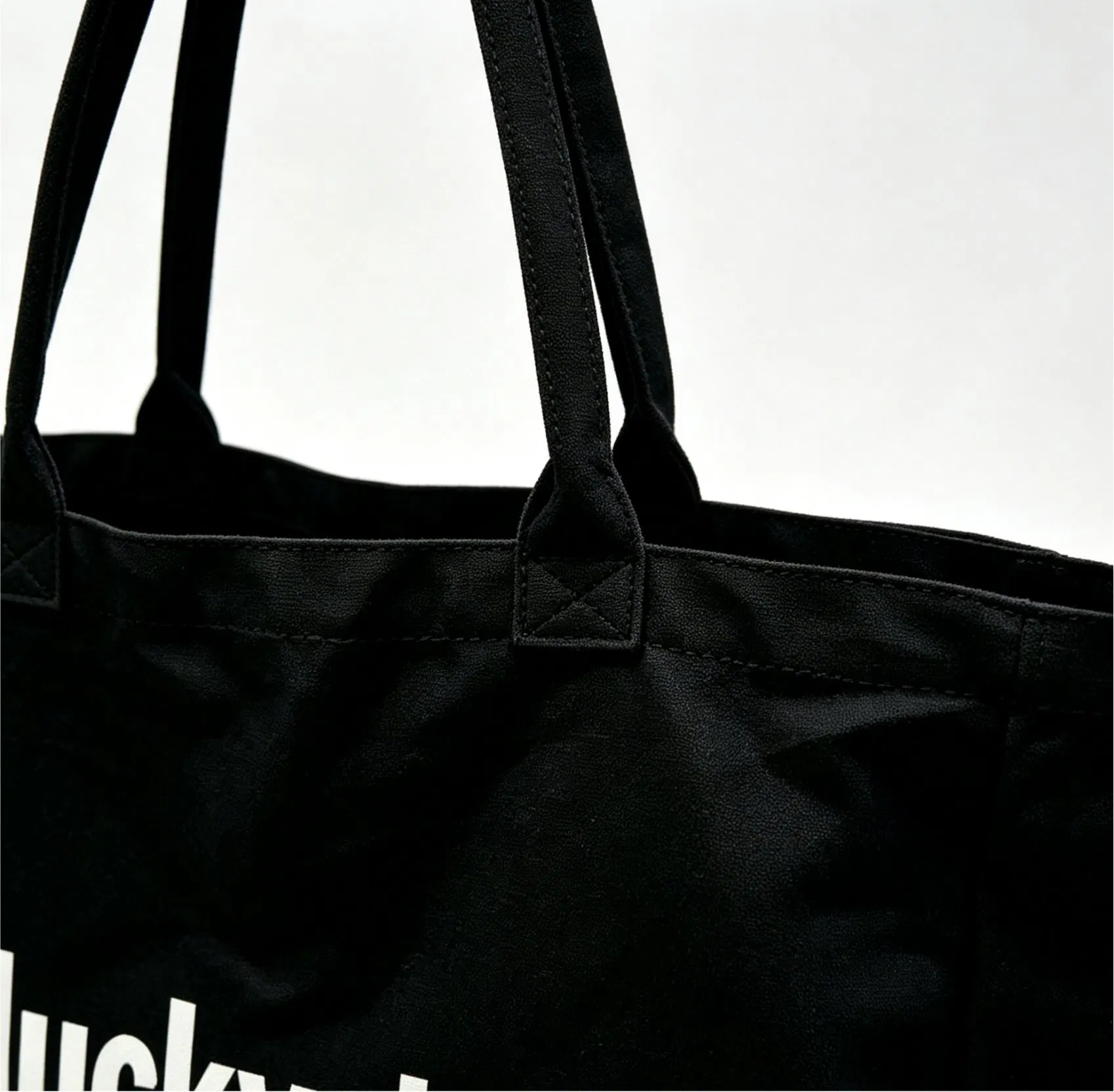 Close view of a canvas shopping bag handle and seam construction