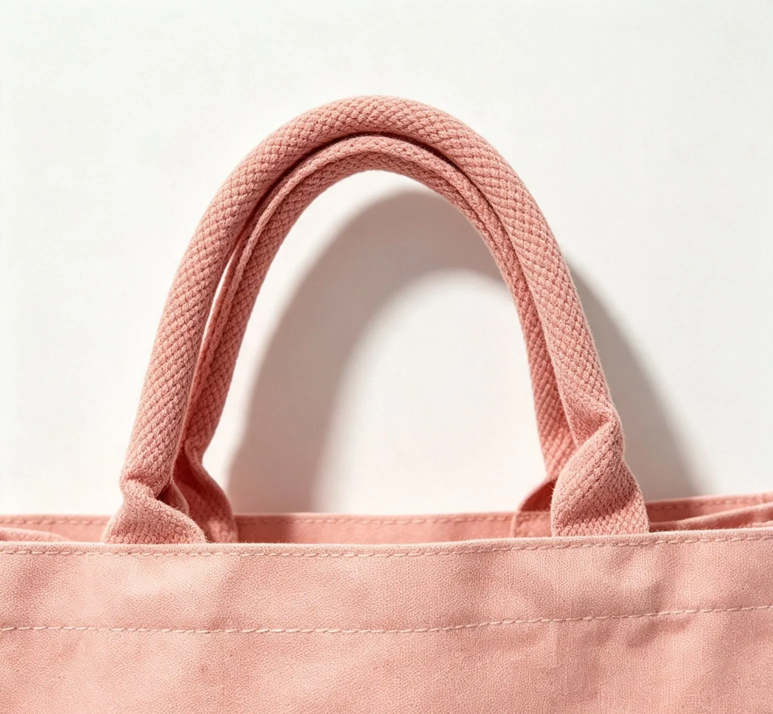 Close view of pink shopping bag handles and upper edge